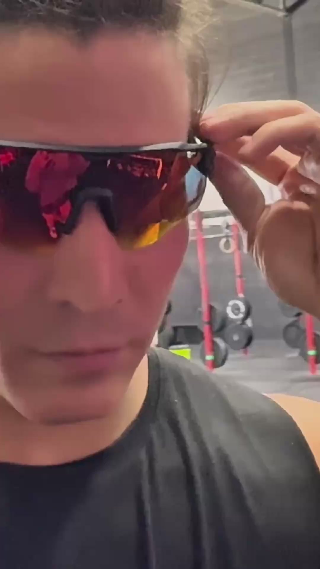 Man adjusting red polarized outdoor sports glasses